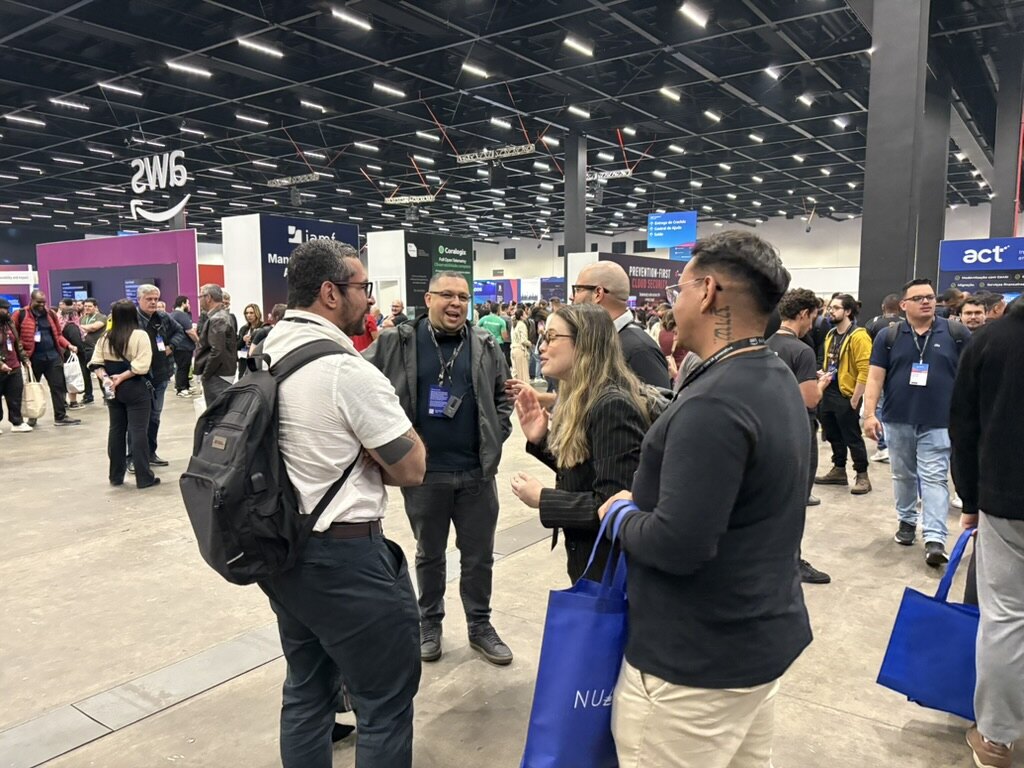 Participantes conversando na área de exposição do AWS Summit São Paulo anterior.